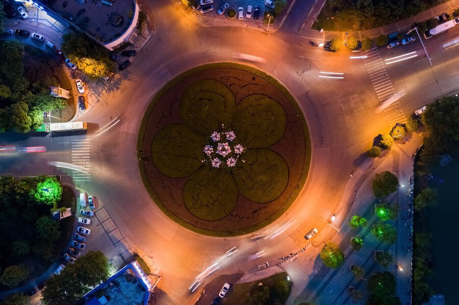 Aerial view of a roundabout at night with cars driving through